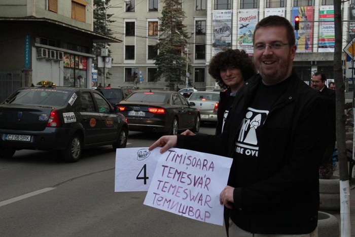 Musai-Muszáj activists line the streets of downtown Kolozsvár. In this photo, they display the name of the Transylvanian town of Timișoara/Temesvár in Romanian, Hungarian, German and Serbian. Photo: Facebook.