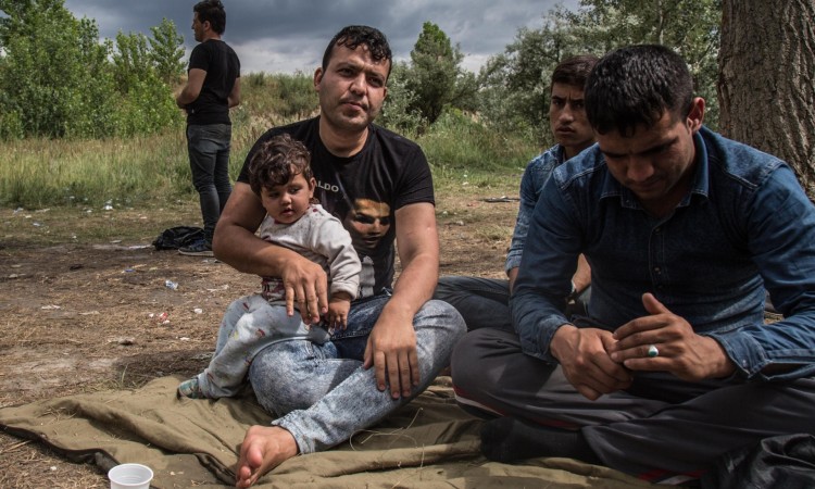 Dr.Yama Nayab, sits with his daughter in Szabadka (Hungarian-dominated northern Serbia), waiting to cross into Hungary. Dr. Nayab was a surgeon in Afghanistan. Photo: Sima Diab/The Guardian. 