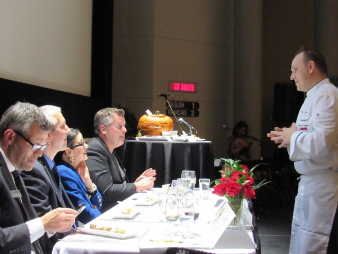 Zsolt Varga presenting his meal to a panel of judges at the 2015 Embassy Chef Challenge, held at Victoria Hall, in the John F. Diefenbaker building. Photo: C. Adam.
