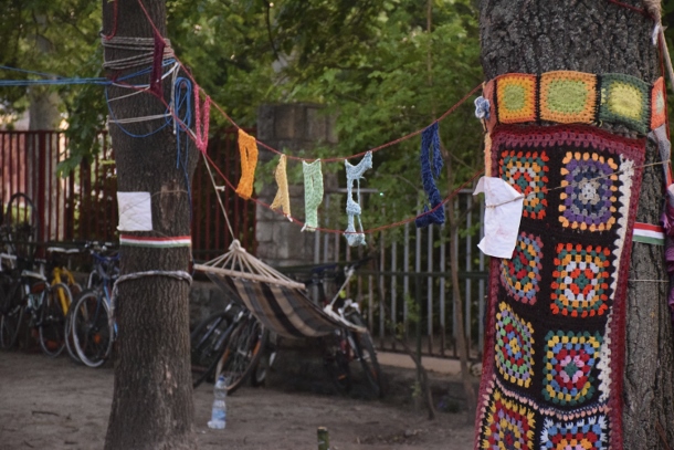 Artists decorate the camp and trees, spelling out “Budapest” in a crochet sign. Photo Credit: Colby Hopkins