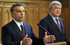Sándor Csányi, standing to the right of Prime Minister Viktor Orbán, at a press conference.